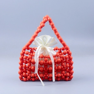 Detail of coral orange beaded handbag with white satin drawstring liner and ribbon