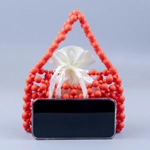 Detail of coral beaded woven handbag with white satin drawstring liner and matte finish
