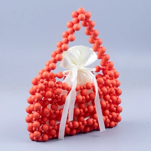 Detail of coral orange beaded handbag with matte beads and white satin drawstring liner