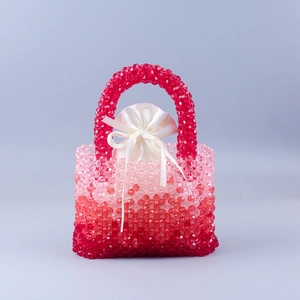 Close-up of handmade beaded handbag with red gradient crystals and satin drawstring liner