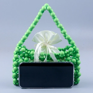 Detail view of green beaded handbag with satin lining and smartphone size reference
