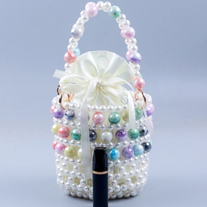 Detail of beaded bucket bag showing white pearls and colorful textured beads with satin liner