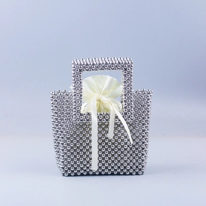 Detail of silver beaded handmade handbag with white satin drawstring pouch inside
