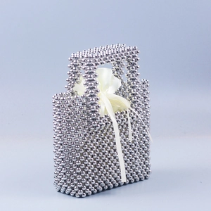 Silver beaded handmade tote bag with shiny metallic finish and cream satin drawstring pouch