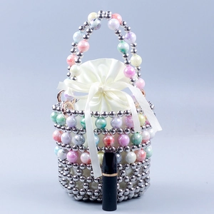 Detail of beaded woven handbag featuring gradient pearls and satin drawstring pouch