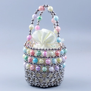 Detail of beaded cylinder handbag with iridescent pearls and white satin drawstring liner