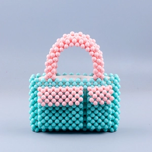 Detail der handgefertigten Perlen-Handtasche mit blauem Korpus und rosa Taschen im Mini-Format
