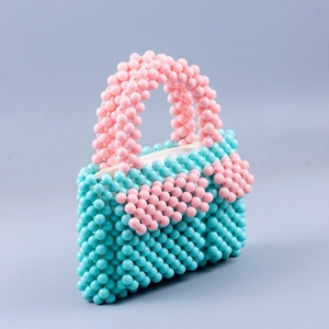 Detailansicht der handgefertigten Perlenblumen auf einer blauen Mini-Perlenhandtasche