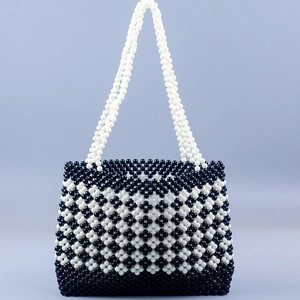 Handmade beaded handbag with black and white clover pattern and long woven handle