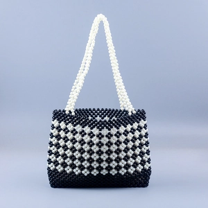 Detail of handmade beaded tote bag with black and white geometric clover pattern