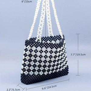 Detail view of handmade beaded clover bag with dimensions showing black and white patterns