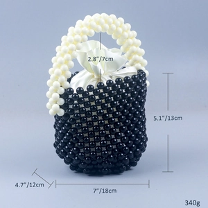 Detail einer handgefertigten schwarzen Perlen-Eimertasche mit weißem Griff und Satinfutter