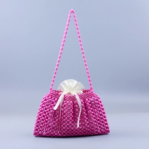 Detail view of pink beaded handbag with internal white satin drawstring pouch and shoulder strap