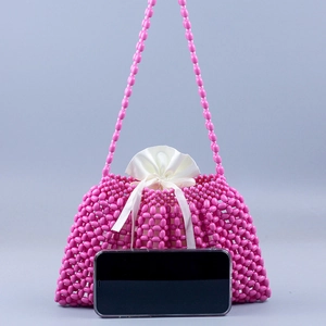Pink handmade beaded tote bag with satin drawstring pouch and smartphone for size reference