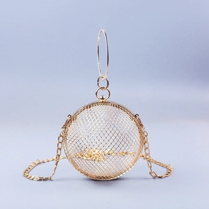 Detail of golden spherical mesh evening bag with metal ring handle and chain strap
