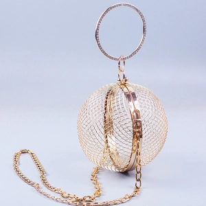 Detailed view of golden spherical metal mesh bag with rhinestone ring handle and chain strap