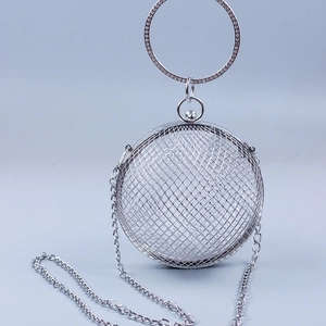 Detail of silver spherical metal mesh evening bag with rhinestone handle and chain strap