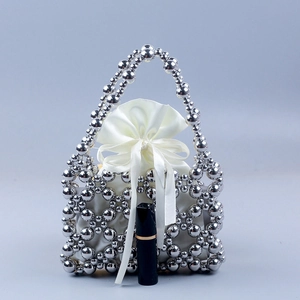Handmade silver beaded tote bag with hollow grid design and white satin drawstring pouch