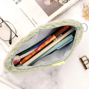 Cute green plush dinosaur pencil case with zipper and large storage capacity on desk