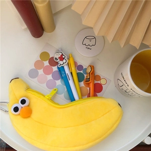 Detail eines bananenförmigen Plüschmäppchens mit süßen Comic-Augen und Metallclip