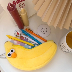 Detailansicht des bananenförmigen Plüschfedermäppchens mit Augen und bunten Stiften