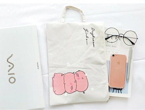 Detail of cream canvas A4 document bag featuring a cute pink cartoon pig print