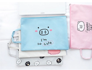 Detail of multi-color cartoon pig file bags with durable zippers and side handles