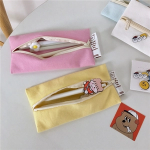 Detail of colorful macaron canvas pencil cases with zipper closure and brand tag