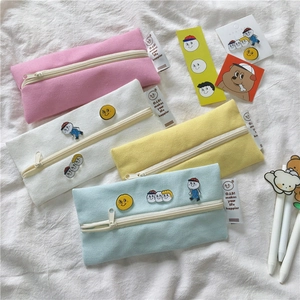Detail of macaron canvas pencil cases showing vintage cartoons and brand labels on fabric
