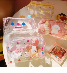 Detail of four transparent PVC makeup bags with cute cartoon prints and zipper closures