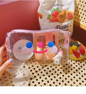 Detailed view of a transparent PVC makeup bag with cute cartoon smiley face and pink zipper