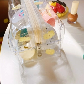 Detail of transparent PVC makeup bag with cute yellow bear print and metal zipper