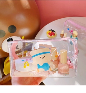 Macro detail of transparent PVC cosmetic bag showing spacious interior and cute bear print