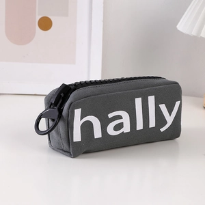 Detail of grey canvas pencil case featuring a large black zipper and hally logo