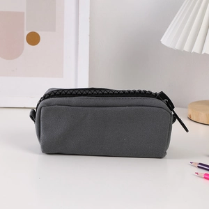 Macro detail of grey canvas pencil case featuring a large tooth black industrial zipper