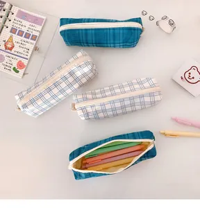 Detail view of a plaid fabric pencil case with navy blue checkers and zipper closure