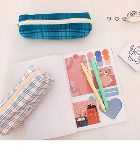 Flat lay of retro plaid canvas pencil cases with zipper closure on minimalist desktop