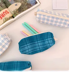 Detail of plaid canvas pencil case with zipper and pastel stationery storage view
