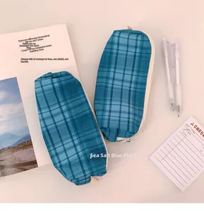 Detail of sea salt blue plaid canvas pencil case with zipper and beige woven pull tab