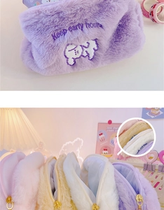 Detail of plush cosmetic bags featuring puppy embroidery and smooth gold zipper closures