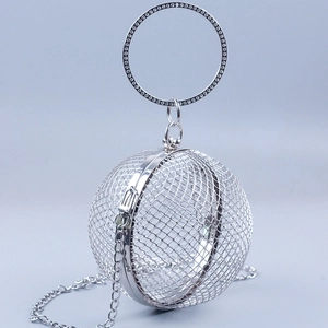 Detail of silver spherical metal mesh handbag with sparkling rhinestone round handle