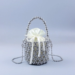 Macro detail of hand-woven silver metal bead bucket bag with drawstring satin lining