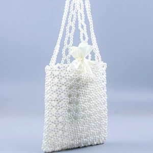 Détail du sac à main en perles fait main avec tissage ajouré et pochette en satin