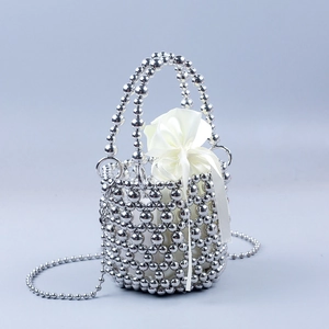 Detail of silver beaded bucket bag featuring a satin drawstring pouch and metal beads