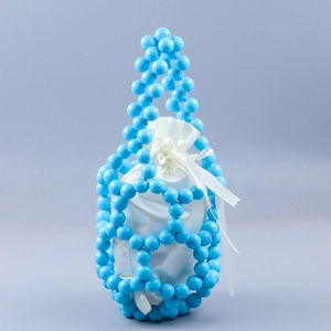 Detailed close-up of blue beaded bucket bag with white satin drawstring lining