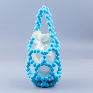 Detail of blue beaded woven bucket bag featuring a white satin drawstring lining