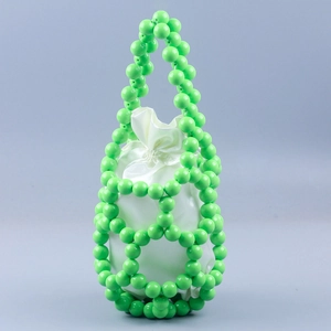 Detail of green beaded bucket bag with white satin drawstring liner and hollow structure