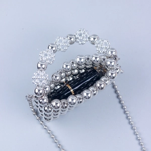 Detail of silver metallic beaded handbag showing internal space with a lipstick