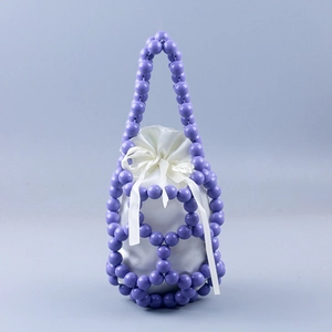 Macro detail of purple beaded bucket bag featuring a white satin drawstring pouch