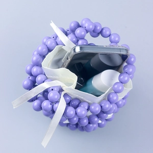 Interior view of purple beaded bucket bag showing storage for phone and lipstick